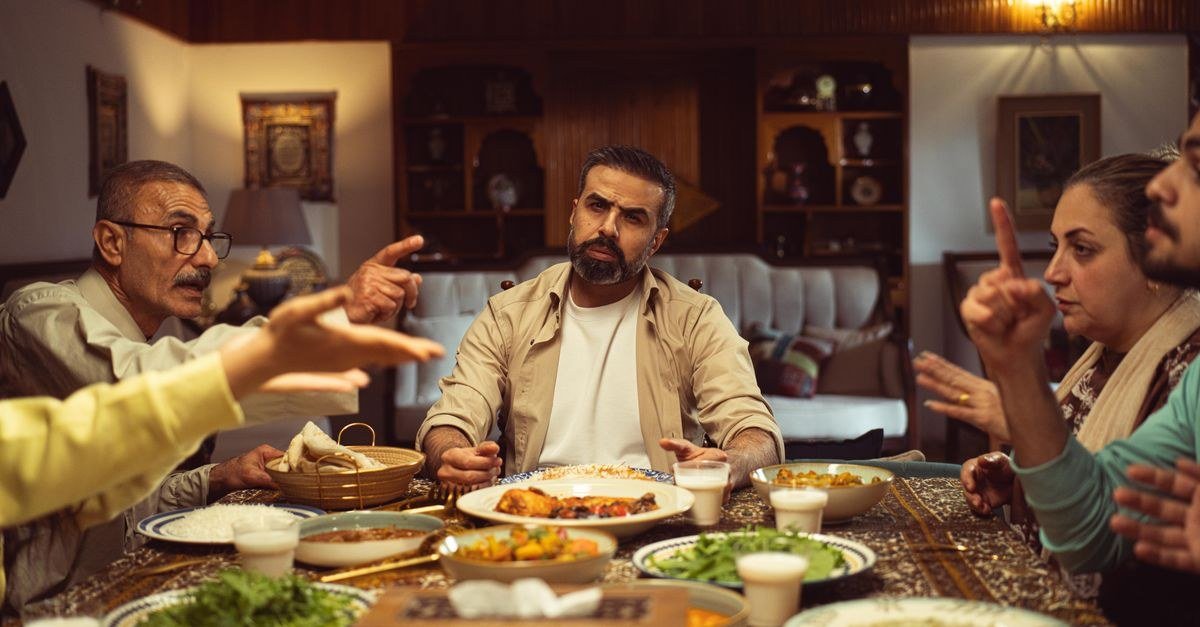 صورة توضح أيام الطفولة الطويلة لعائلة تتبادل القصص حول مائدة الطعام الدافئة