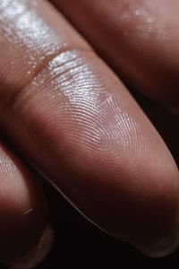 لقطة ماكرو مقرّبة لطرف إصبع رطب تُظهر خطوط بصمة الجلد وتفاصيل نسيجه ولمعان الماء عليه
